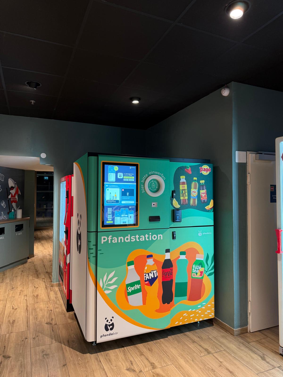 Automated bottle recycling station labeled Pfandstation with beverage graphics.